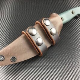 a Scout Style Benchmade Bushcrafter Kydex Sheath on top of the knife.
