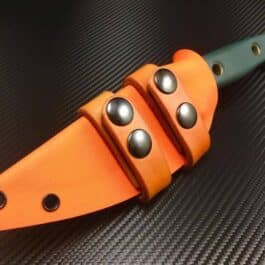 a Scout Style Benchmade Bushcrafter Kydex Sheath with a green handle on a black surface.