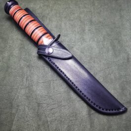 a Handmade Leather Sheath for the Full Size Ka-Bar with a wooden handle on a table.