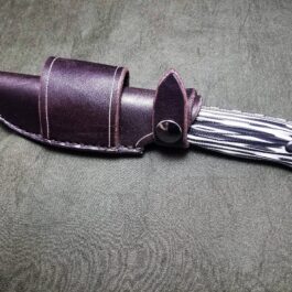 A Leather Scout Sheath For The Benchmade Saddle Mountain Skinner with a black and white pattern.