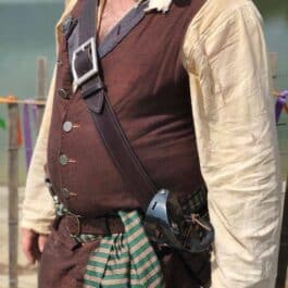 A man in a Pirate Baldric Style 2 costume standing next to a body of water.