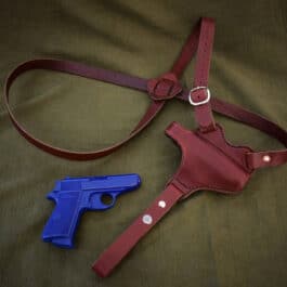 a red Handmade Leather Shoulder Holster and a blue plastic gun.