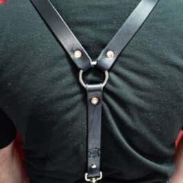 The back of a man wearing handmade leather suspenders.