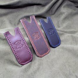 A Handmade Leather Pocket Slip laying on top of a bed.