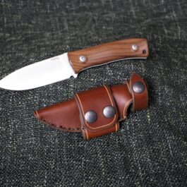 A Lionsteel M4 with a handmade leather sheath on a black cloth.