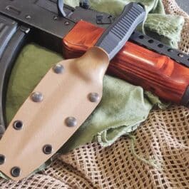 A Kydex Sheath for the Benchmade Fixed Infidel laying on top of a green cloth.