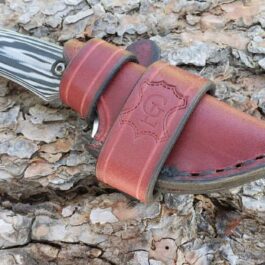 A Leather Scout Sheath for the Benchmade Hidden Canyon Hunter on a rock.