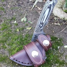A Leather Scout Sheath for the Benchmade Hidden Canyon Hunter on the ground.