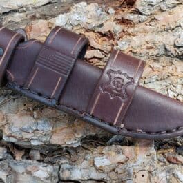 A brown Leather Scout Sheath for the Short Ka Bar Fighting Knife on a rock.