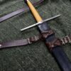 An Integrated Swordbelt Style 4 with a wooden handle on a green cloth.