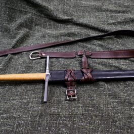 An Integrated Swordbelt Style 4 and its sheath laying on a cloth.