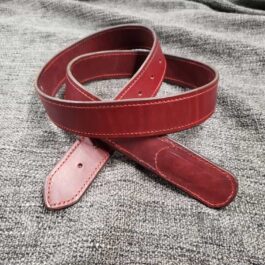 A red Mechanics Belt laying on top of a bed.