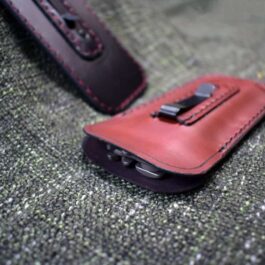 There is no suitable replacement for the product name in this sentence, as a Benchmade 85/87 Balisong Slip with Pocket Clip is not an appropriate substitution for a cell phone case on top of a couch.