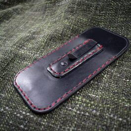 black with red stitches Leather Balisong Slip With Pocket Clip laid on a cloth - renaissance clothing - renaissance clothing men - renaissance clothing women - renaissance clothing near me - renaissance art clothing - renaissance era clothing - renaissance costume ideas