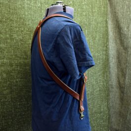 A man wearing a blue shirt and a Handmade Leather Side Clip Suspenders.