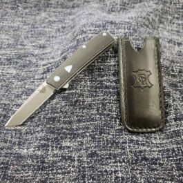 A Leather Pocket Slip for the Benchmade Tengu w' Pocket Clip laying on top of a piece of cloth.