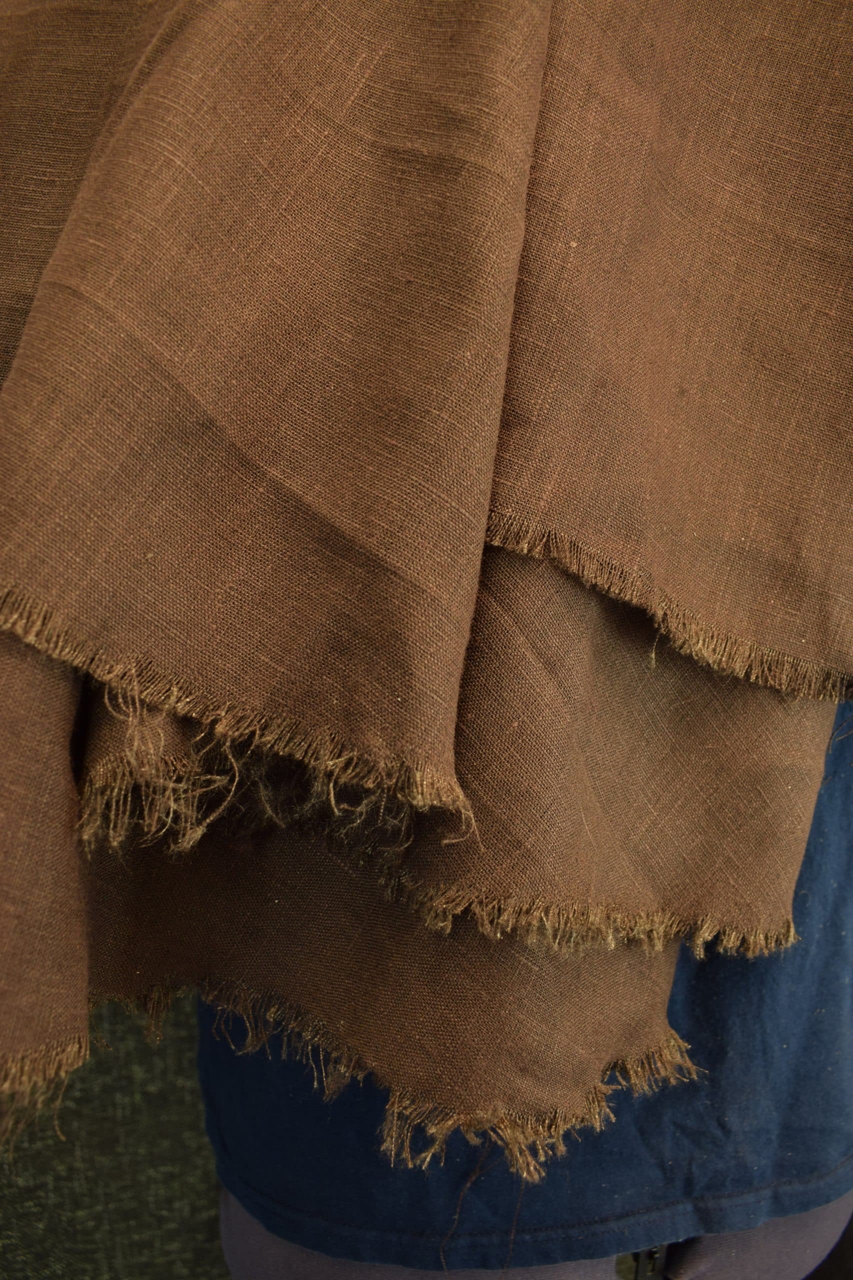 A close up of a person wearing a Linen Hooded Cloak.