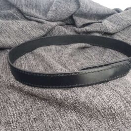 A Mechanics Belt laying on top of a bed.