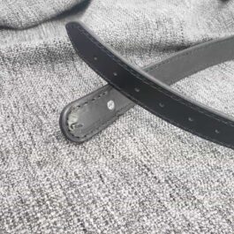 A Mechanics Belt laying on top of a gray cloth.