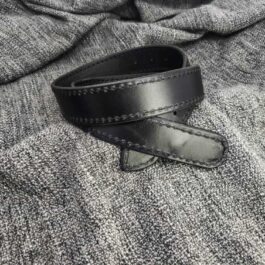 A Mechanics Belt, black leather, is laying on top of a gray cloth.