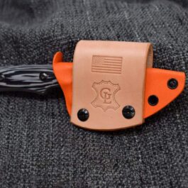 A Scout Style Kydex Sheath for Benchmade Hidden Canyon Hunter in orange and black leather on a black cloth.