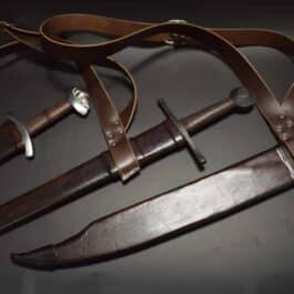 A Custom Wood Core Scabbard with a leather strap around it.