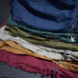 a pile of linen hooded cloaks sitting on top of each other.