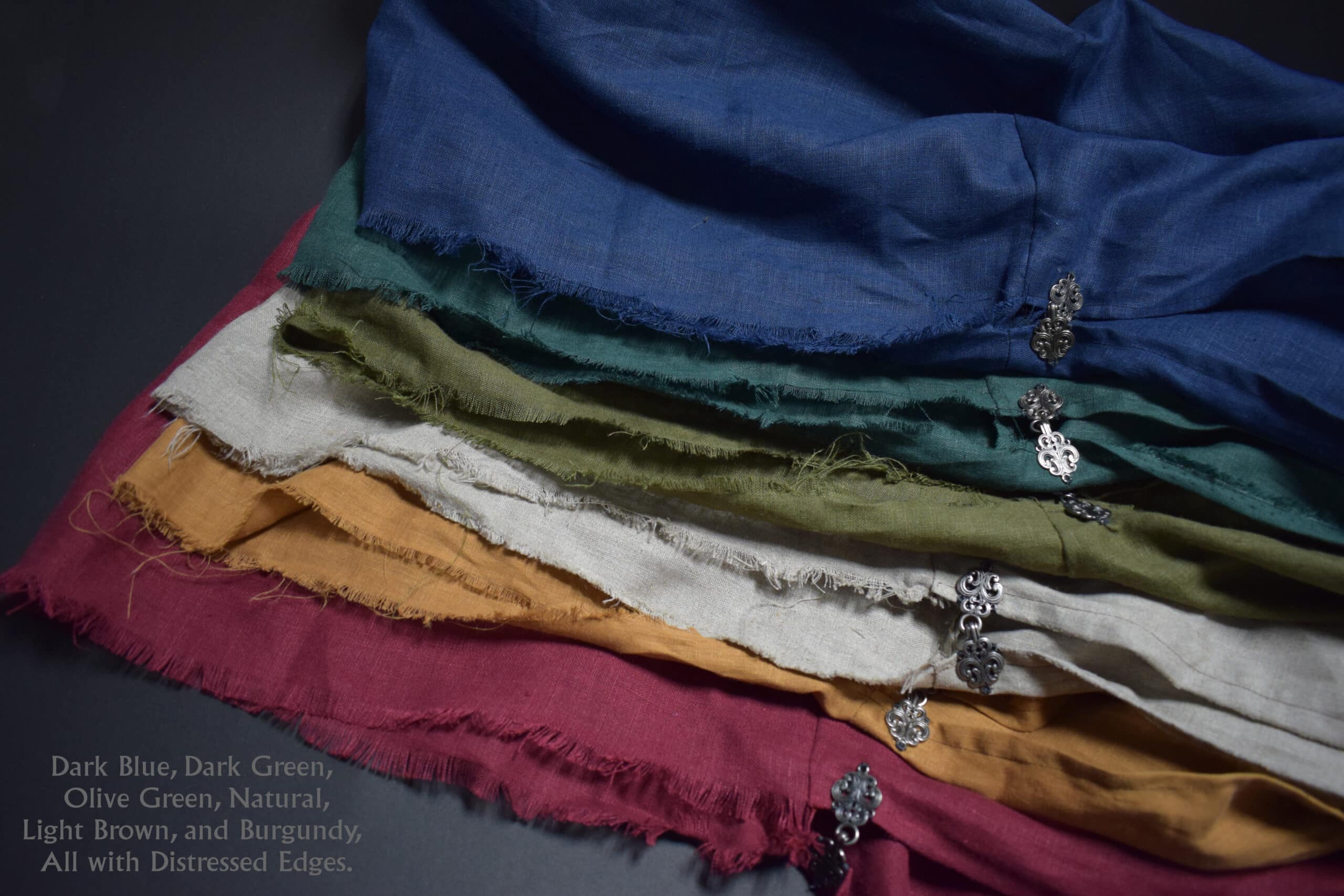 a pile of linen hooded cloaks sitting on top of each other.