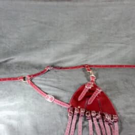 a pink and red piece of leather sitting on top of a bed.