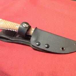 a knife with a leather sheath on a red cloth.
