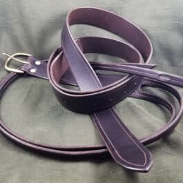 A Integrated Sword Belt laying on a bed.