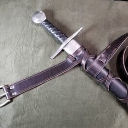 An Integrated Sword Belt laying on a bed.