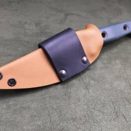 A Scout Style Benchmade Bushcrafter Sheath Style 2 with a leather sheath on a table.
