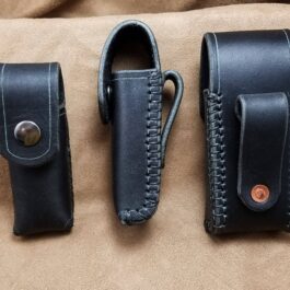 A couple of black Handmade Leather Pouches sitting on top of a couch.