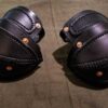 two black leather elbow armor laid on a cloth - renaissance clothing - renaissance clothing men - renaissance clothing women - renaissance clothing near me - renaissance costume ideas - sword baldrics - baldrics leather - baldric belt