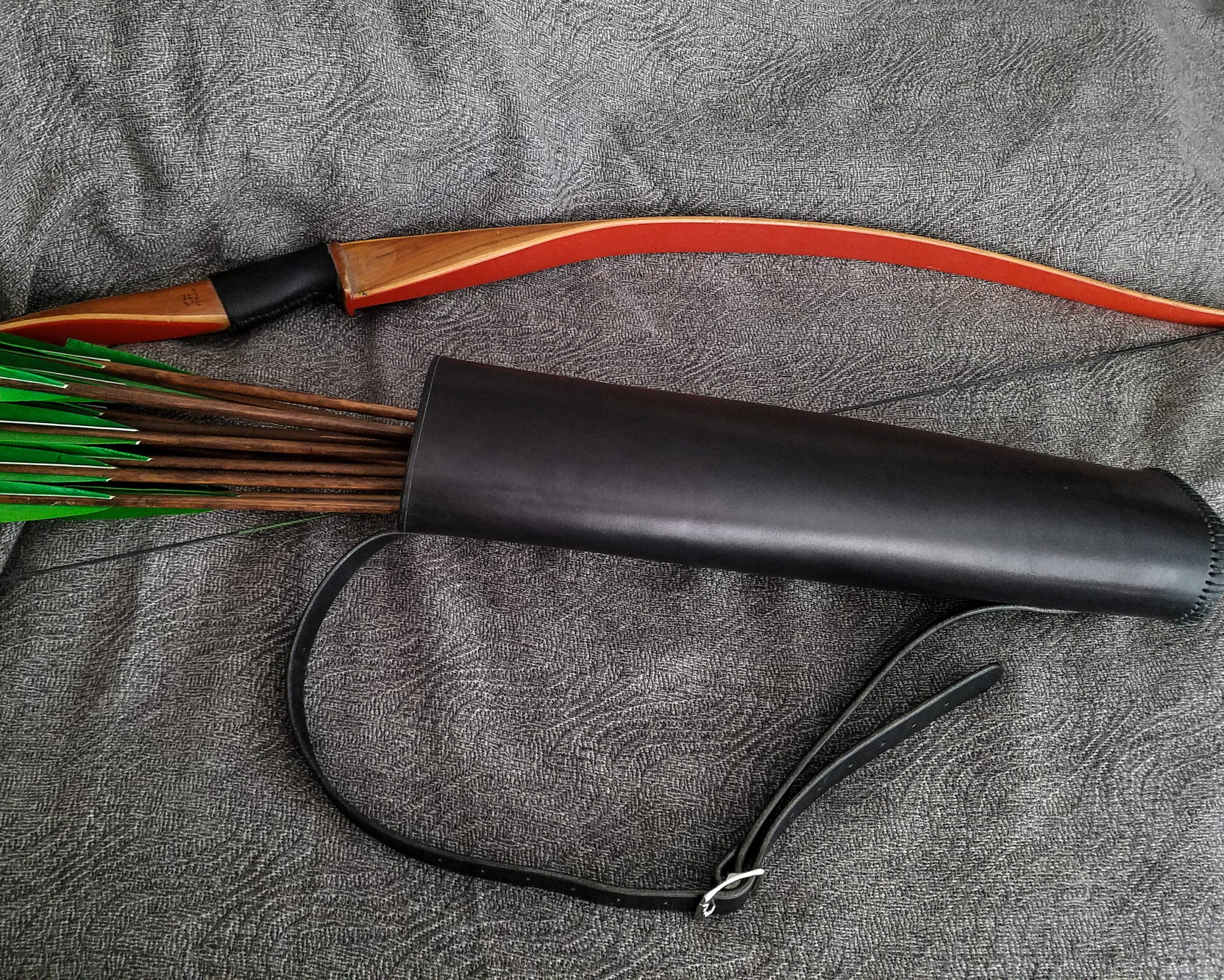 a black Basic Back Quiver laid on a cloth - renaissance clothing - renaissance clothing men - renaissance clothing women - renaissance clothing near me - renaissance costume ideas - sword baldrics - baldrics leather - baldric belt