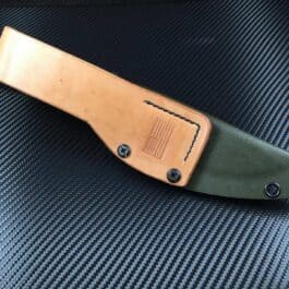 The TOPS HOG 4.5 Kydex Sheath sitting on top of a piece of leather.