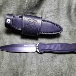 A purple Benchmade Fixed Infidel knife with a Handmade Leather Sheath on a gray cloth.