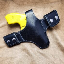 a Handmade Leather Snap Loop Pancake Holster with a yellow handle.