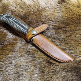 a knife is laying on a fur covered surface.