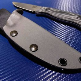 a Kydex sheath for the Benchmade Saddle Mountain Hunter sitting on top of a blue table.
