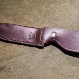 a brown leather knife case sitting on top of a table.