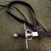 a black simple baldric laid on a cloth - renaissance clothing - renaissance clothing men - renaissance clothing women - renaissance clothing near me - renaissance costume ideas - sword baldrics - baldrics leather - baldric belt