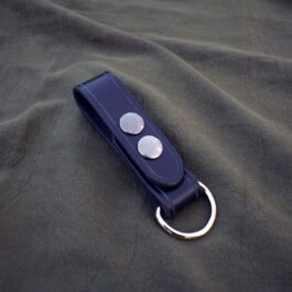 A Leather Dangler Loop with two buttons on a black cloth.