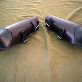 a pair of brown shoes sitting on top of a bed.