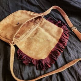 A Frontier Suede Saddlebag sitting on top of a bed.