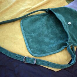 A Frontier Suede Saddlebag sitting on top of a bed.