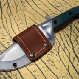 A Scout Style Benchmade Bushcrafter Sheath Style 2 on a table.
