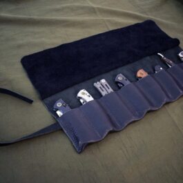 A Handmade Leather Knife/Tool Roll holds a variety of electronic devices.