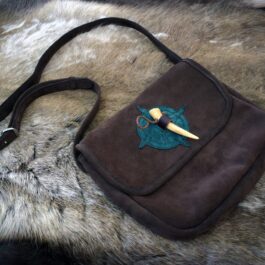 A Frontier Suede Saddlebag with a green bird on it.